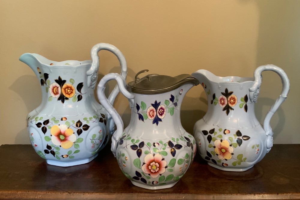 A trio of Pompeii design pottery jugs