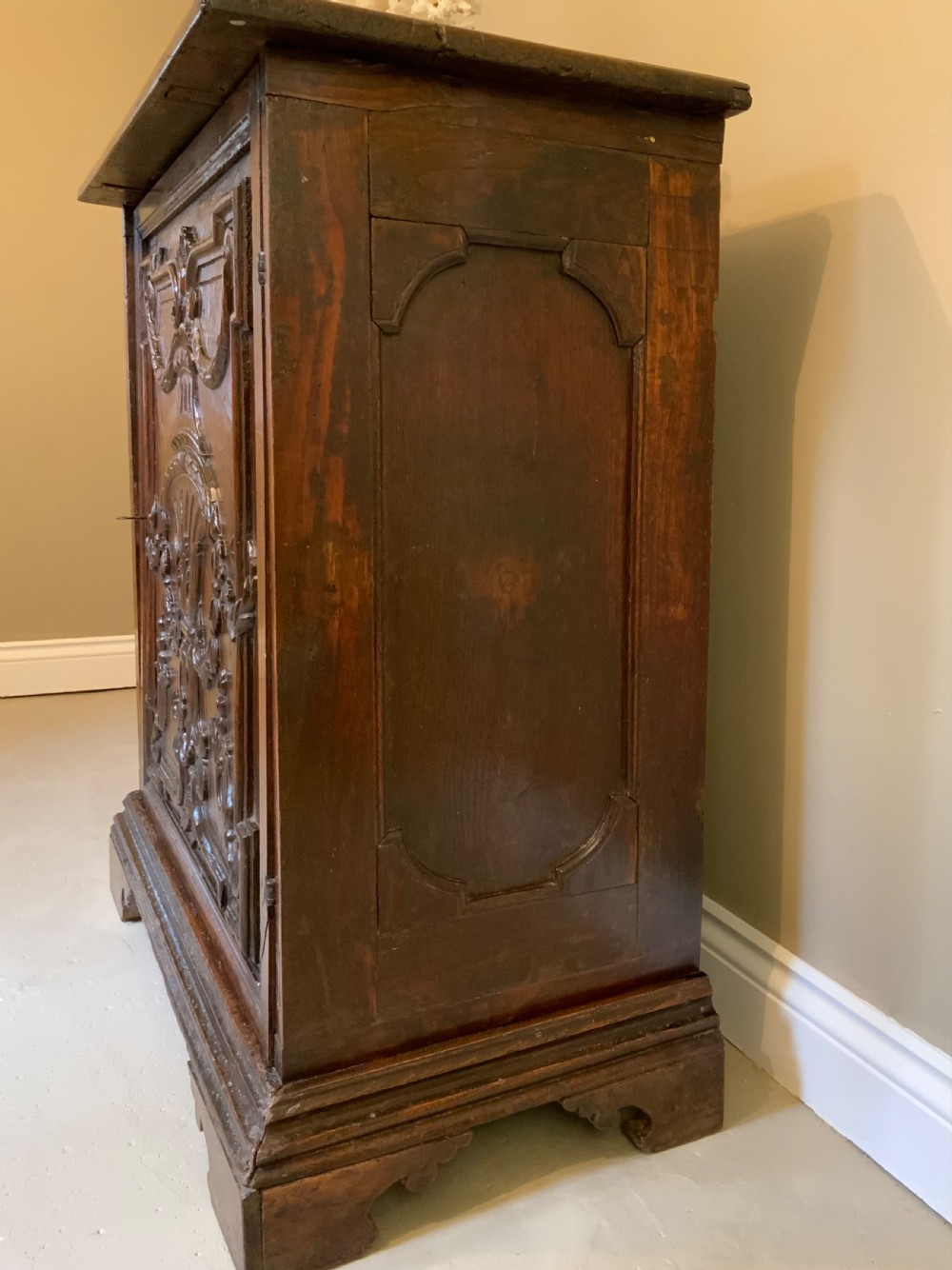 An Italian walnut Baroque cabinet featuring a single door decorated with relief carvings of an urn and floral garlands on a moulded plinth base. View IV