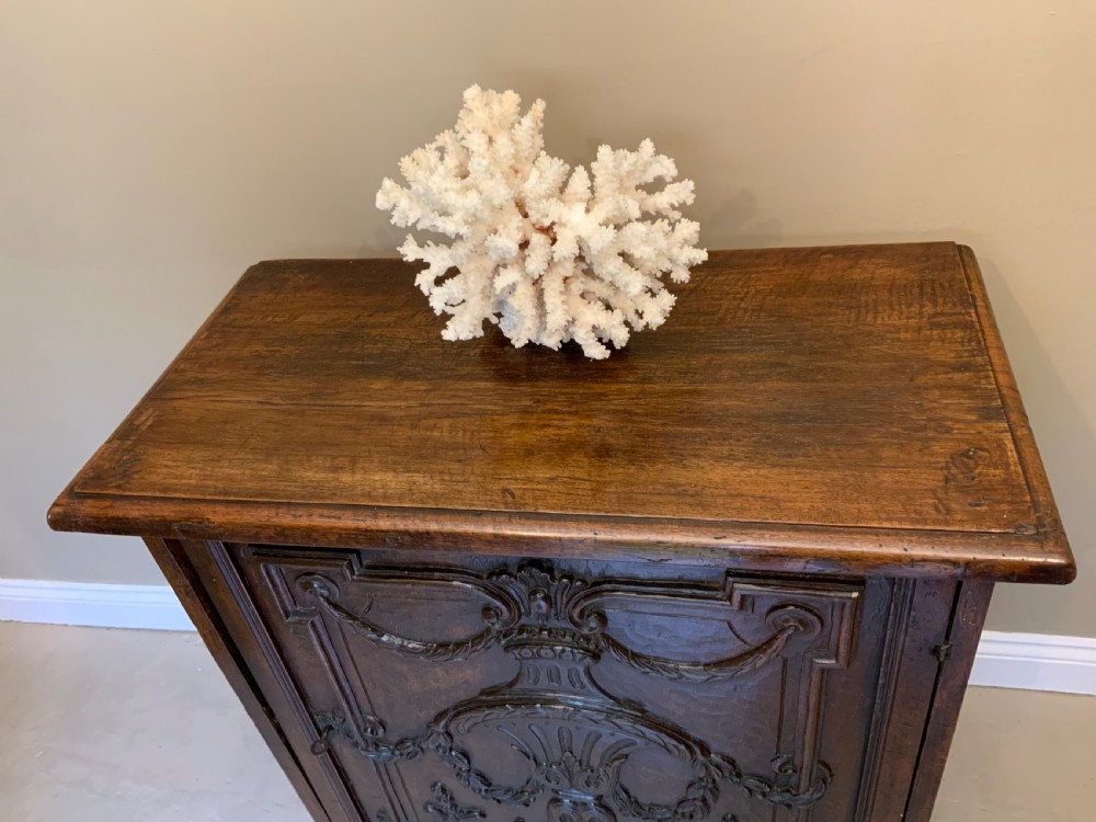 An Italian walnut Baroque cabinet featuring a single door decorated with relief carvings of an urn and floral garlands on a moulded plinth base. View VII