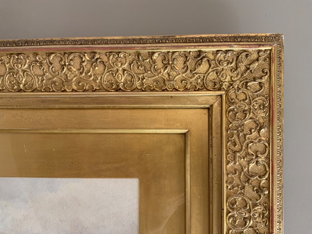 A framed 19th-century watercolour painting depicting a river running through a green landscape with trees and distant hills, set within an ornate gold gilt frame. View IV