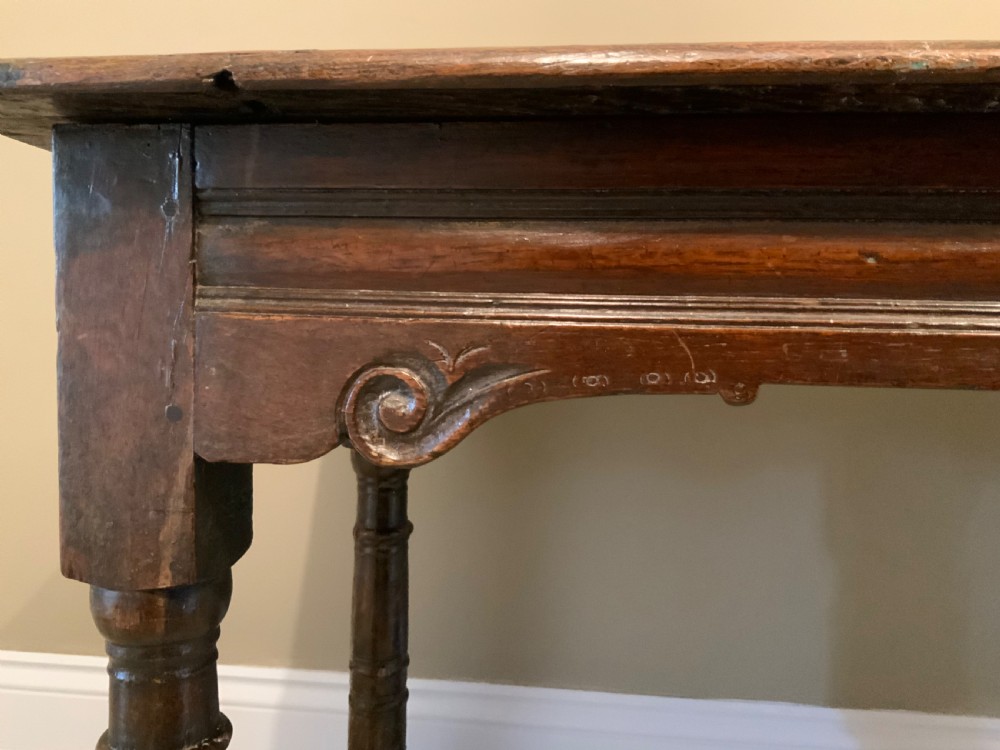 A 17th-century dark oak side table featuring turned legs, carved scroll spandrels, and lower stretcher rails. View II