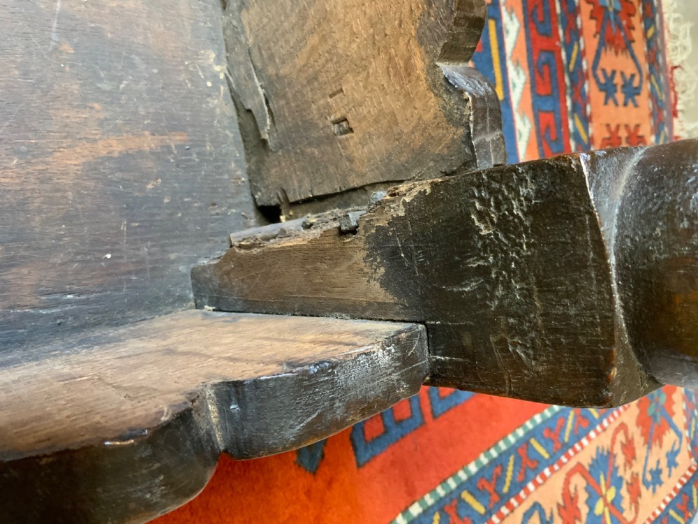 A 17th-century dark oak side table featuring turned legs, carved scroll spandrels, and lower stretcher rails. View X