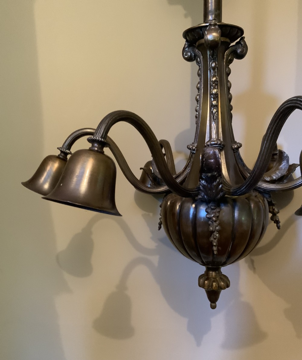 A dark patinated bronze five-arm chandelier featuring downward-facing bell shades, reeded scroll arms, and an ornate central stem. View II