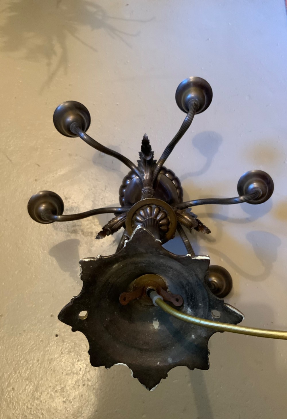 A dark patinated bronze five-arm chandelier featuring downward-facing bell shades, reeded scroll arms, and an ornate central stem. View V