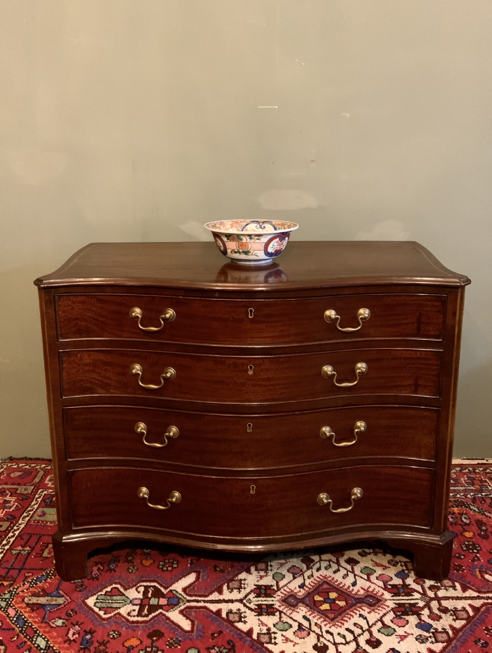 A George III serpentine chest of drawers