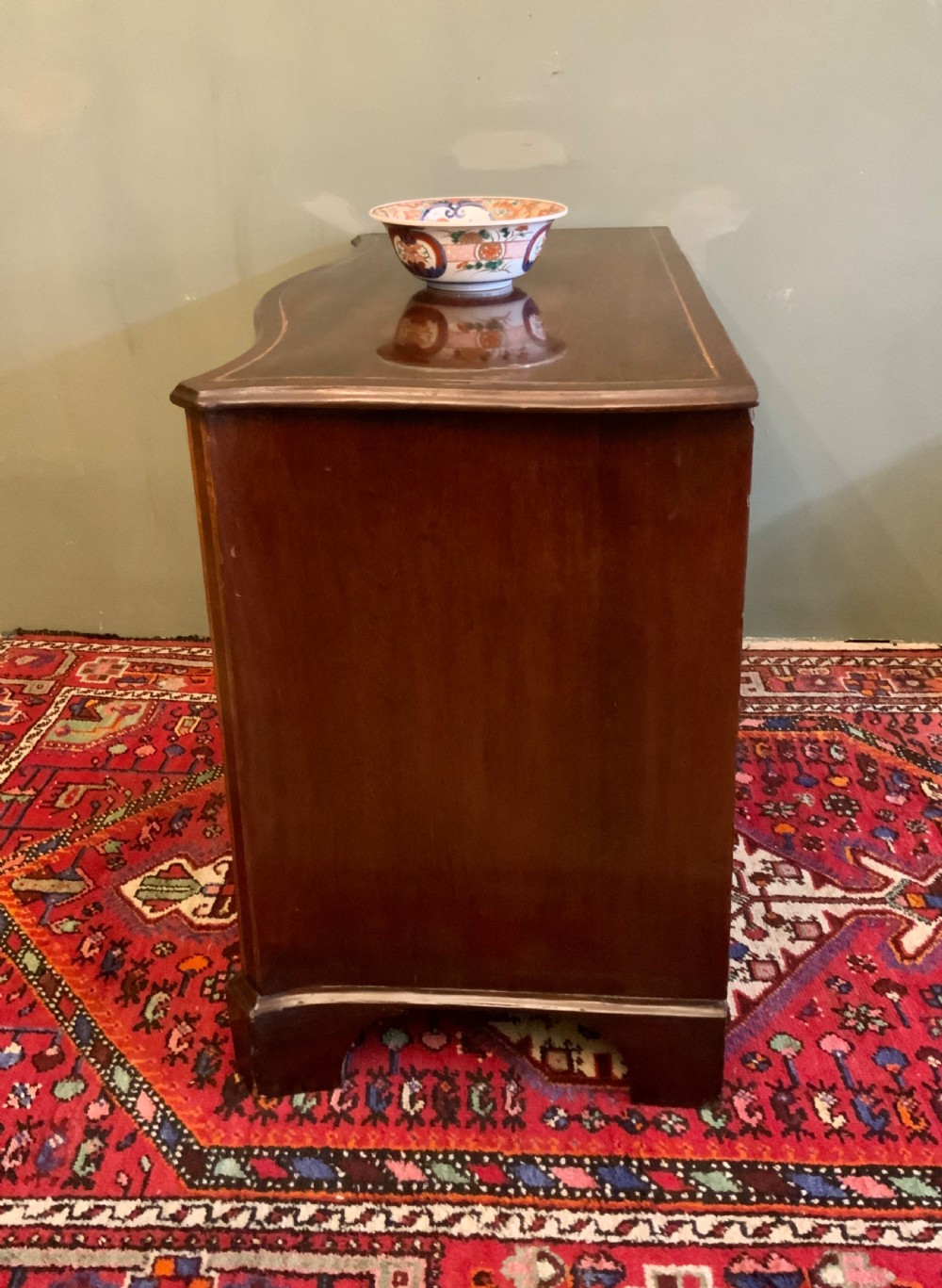 A George III serpentine chest of drawers View III