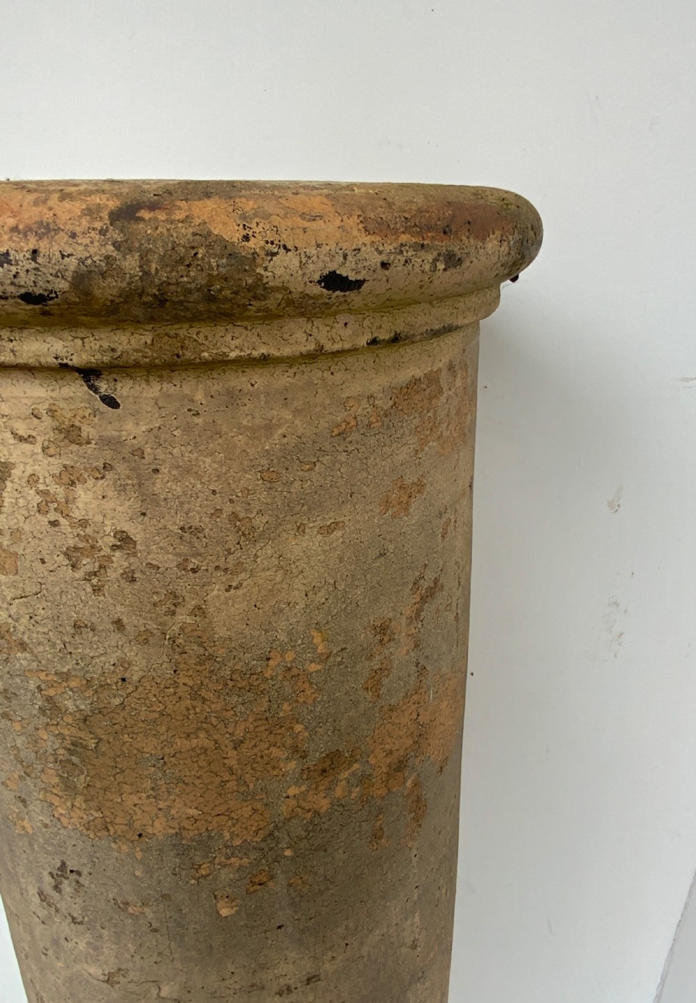 A tall cylindrical buff clay chimney pot featuring rolled rims at the top and base with natural lichen and weathered patination. View II