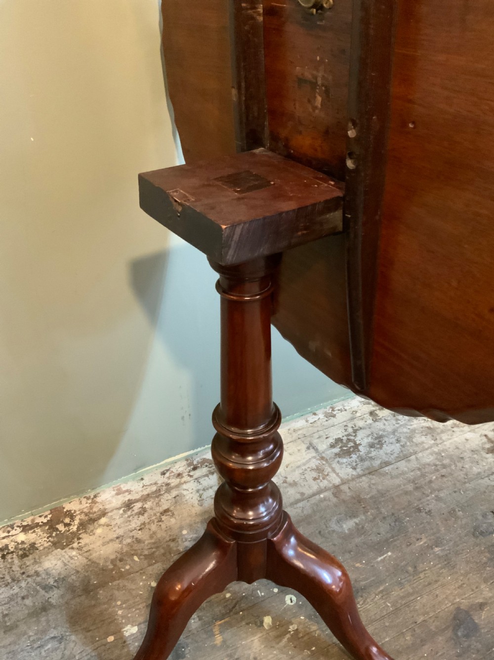 An antique Georgian mahogany tilt-top tripod table with a scalloped piecrust rim, turned central pedestal, and three cabriole legs. View IV