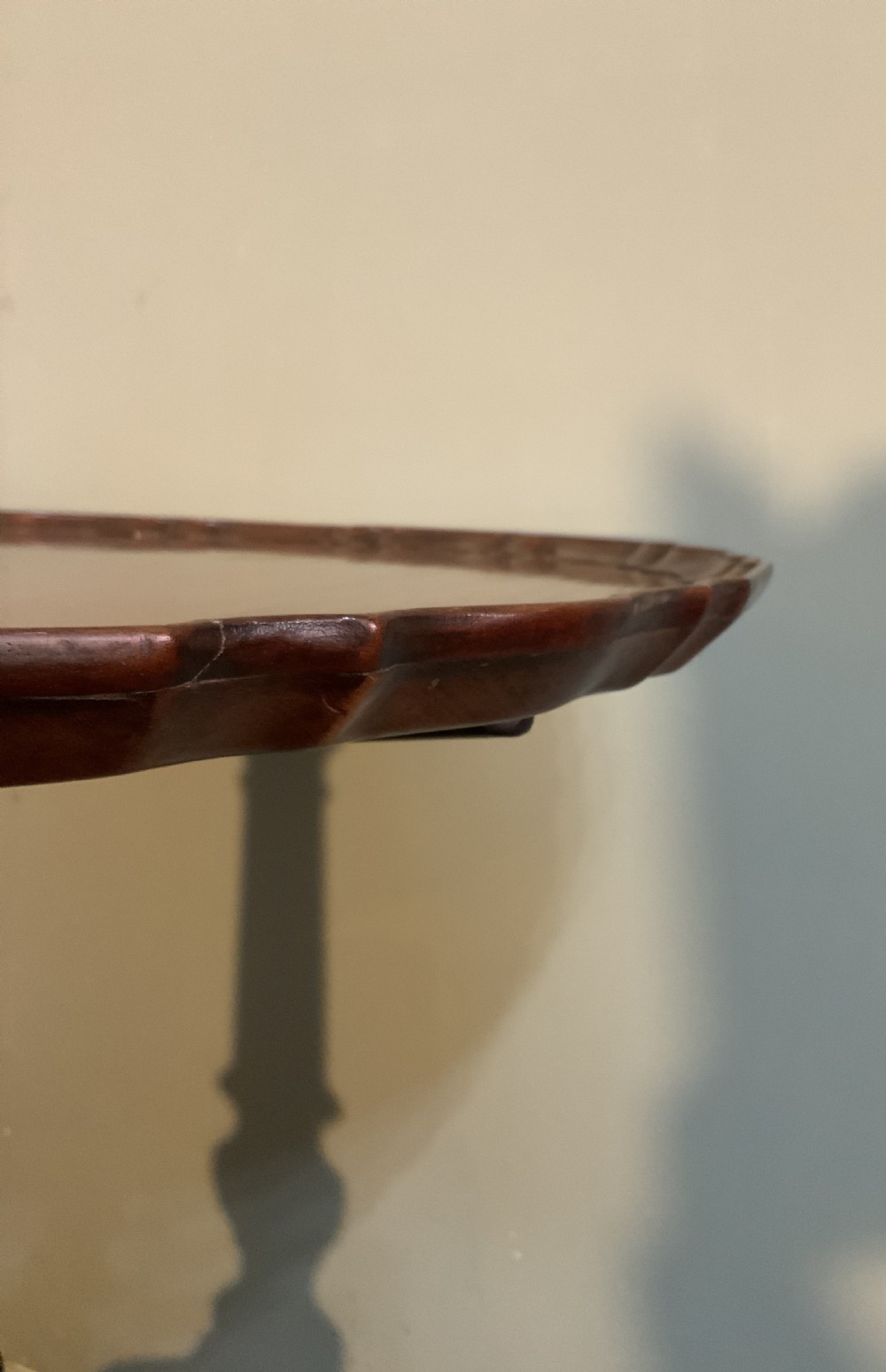 An antique Georgian mahogany tilt-top tripod table with a scalloped piecrust rim, turned central pedestal, and three cabriole legs. View VIII