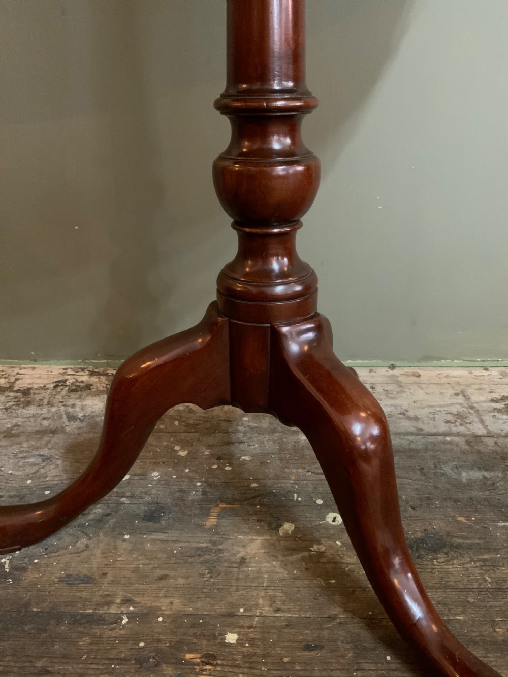 An antique Georgian mahogany tilt-top tripod table with a scalloped piecrust rim, turned central pedestal, and three cabriole legs. View IX