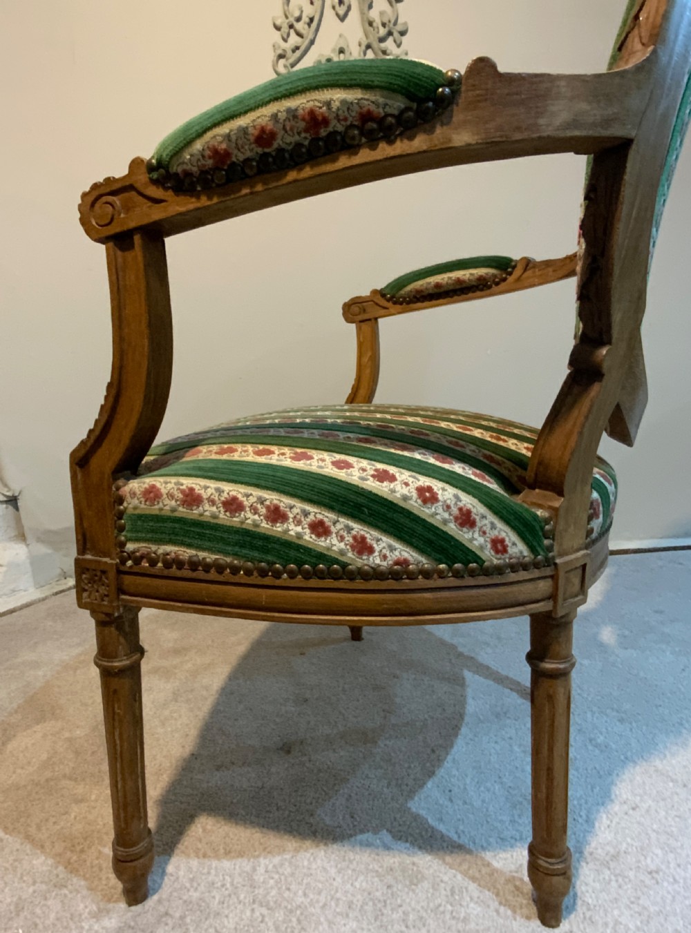 A pair of 19th-century French armchairs featuring carved wooden frames, oval backrests, and green and cream striped fabric upholstery. View XIII