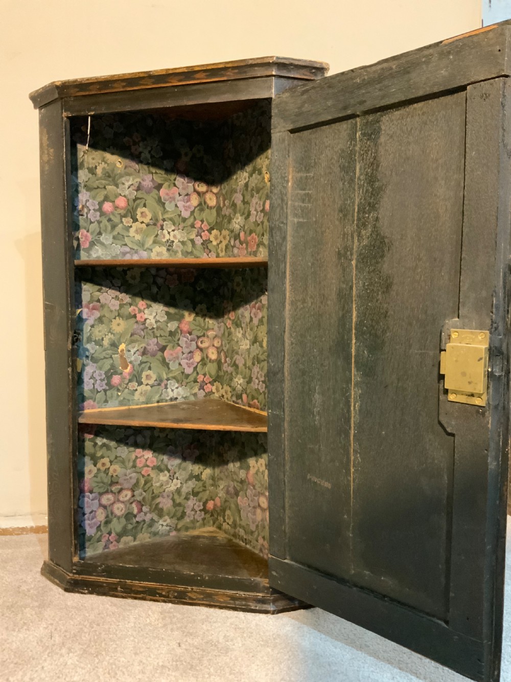 An 18th-century black lacquered corner cabinet featuring gilt chinoiserie artwork of figures, architecture, and a parrot, fitted with decorative brass hinges. View III
