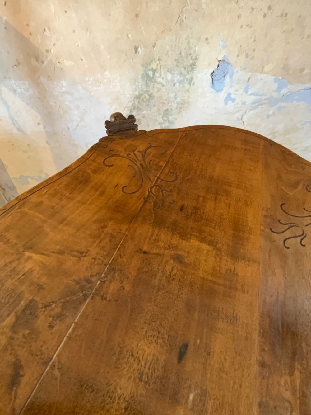 A carved Italian walnut three-legged occasional table featuring sculptural legs shaped like mythical figures terminating in claw feet with a lower undertier shelf. View VII