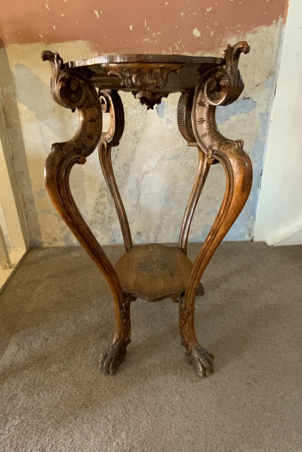 A carved Italian walnut three-legged occasional table featuring sculptural legs shaped like mythical figures terminating in claw feet with a lower undertier shelf. View VIII