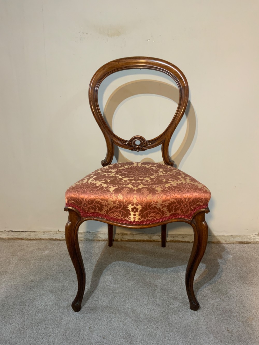 A set of six early Victorian rosewood balloon-back dining chairs with red damask upholstery and cabriole legs. View III