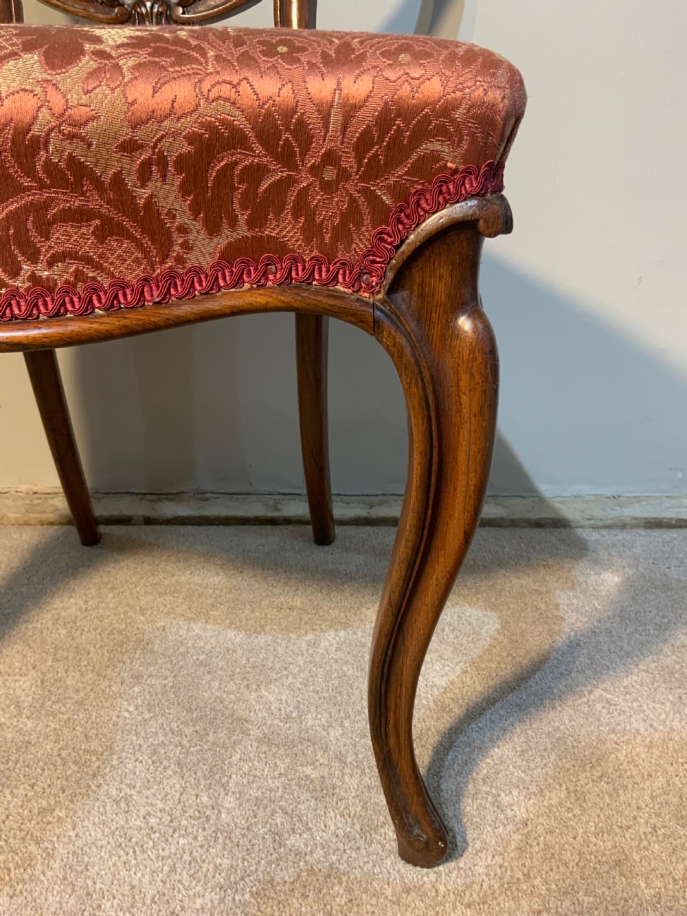 A set of six early Victorian rosewood balloon-back dining chairs with red damask upholstery and cabriole legs. View V