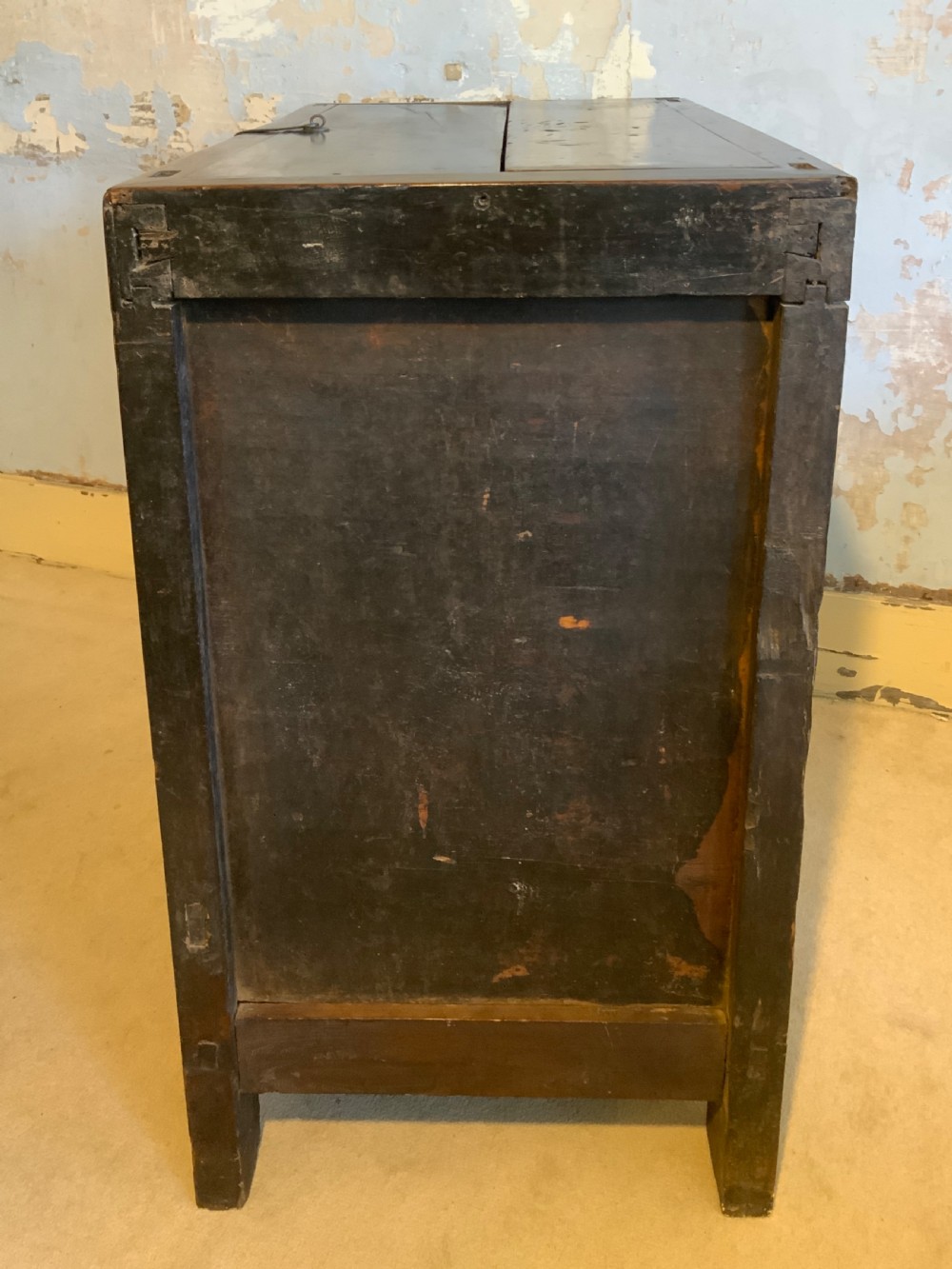 A dark brown 18th-century Chinese wooden chest featuring a top-opening lid, two lower drawers with metal ring handles, and iron latch hardware. View X