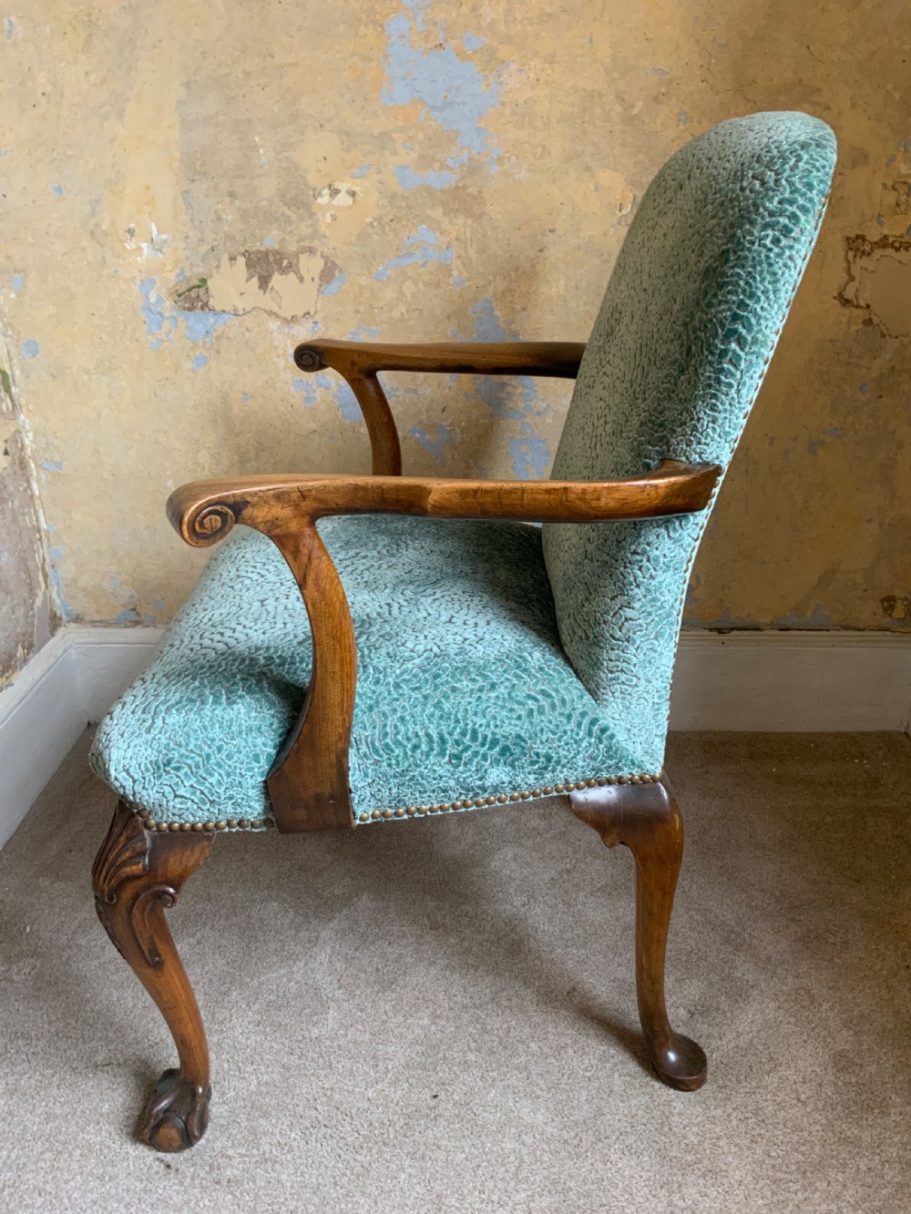 An antique walnut open armchair featuring light green textured upholstery, carved cabriole legs with ball and claw feet, and curved wooden armrests. View III