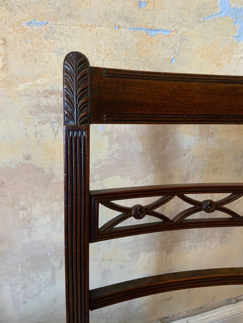 A set of six dark brown mahogany dining chairs featuring open ladder-backs with carved detailing and blue-and-yellow striped upholstered drop-in seats. View VI