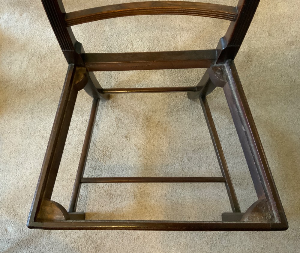 A set of six dark brown mahogany dining chairs featuring open ladder-backs with carved detailing and blue-and-yellow striped upholstered drop-in seats. View VII