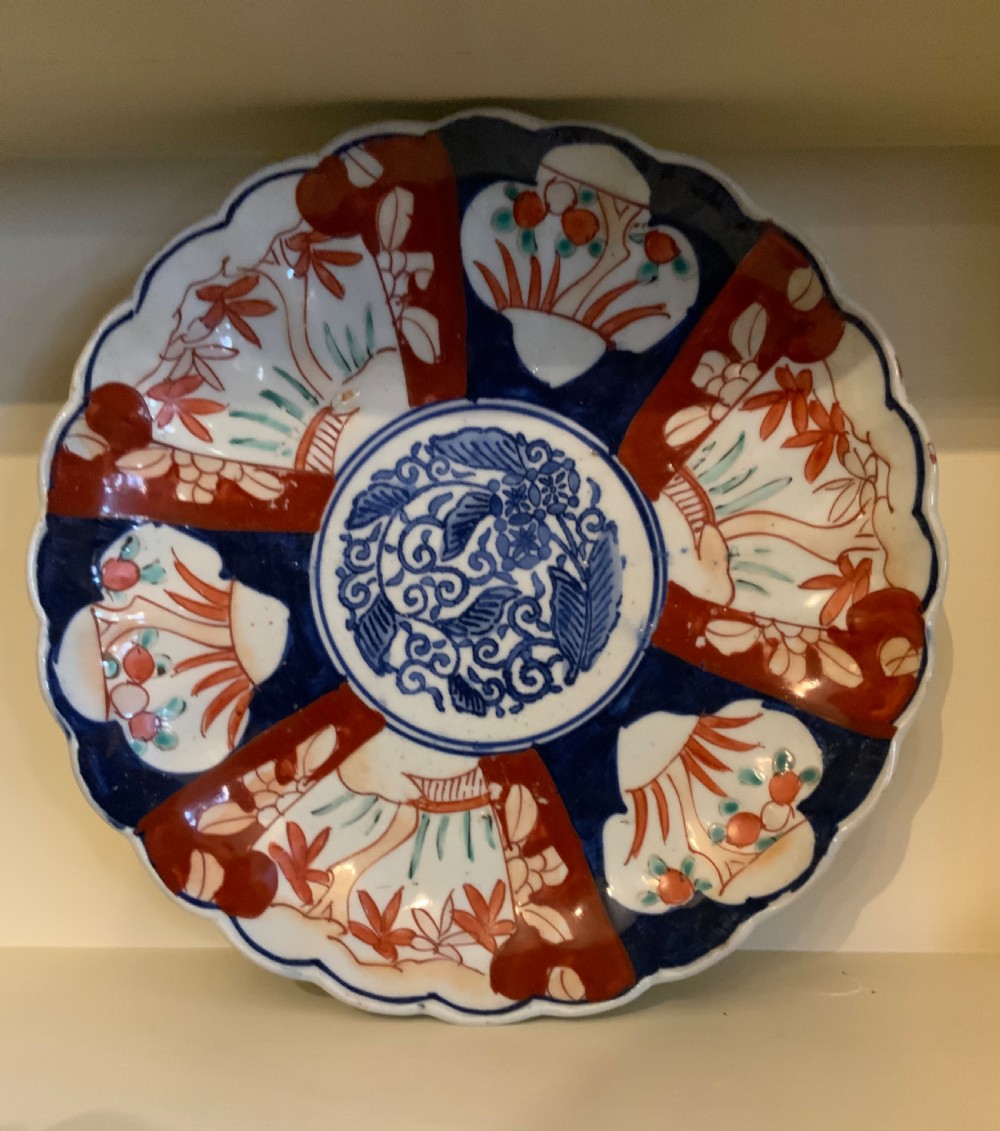A set of four 19th-century Japanese Imari porcelain plates featuring scalloped rims and detailed cobalt blue and iron-red floral panelling. View II