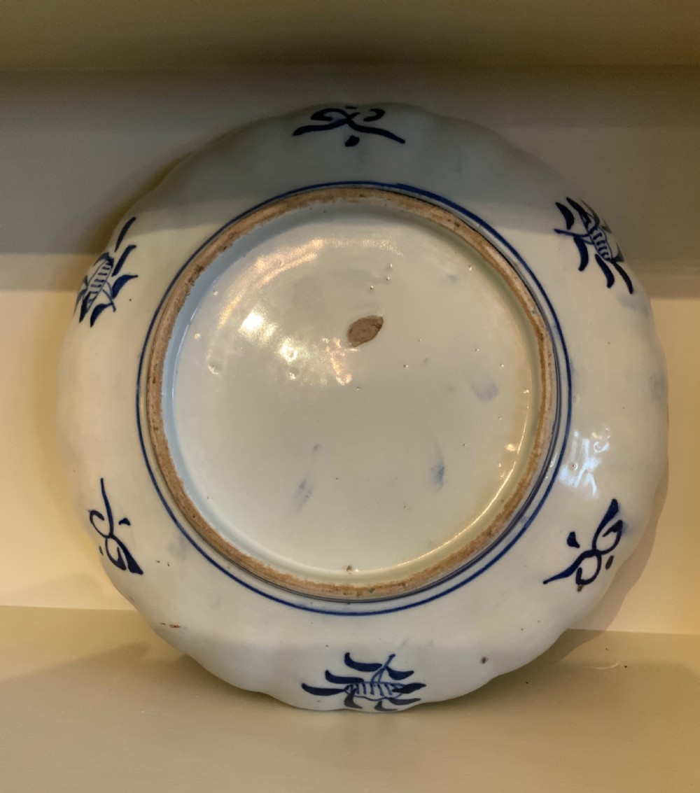 A set of four 19th-century Japanese Imari porcelain plates featuring scalloped rims and detailed cobalt blue and iron-red floral panelling. View III