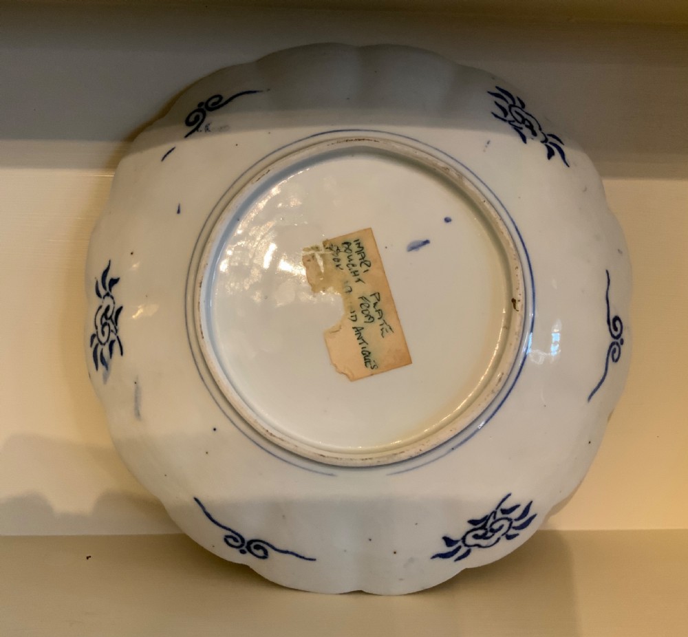 A set of four 19th-century Japanese Imari porcelain plates featuring scalloped rims and detailed cobalt blue and iron-red floral panelling. View V