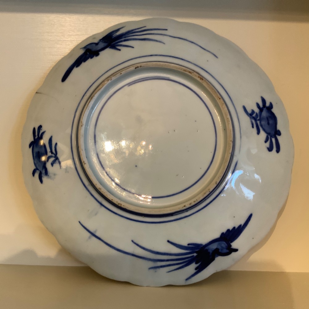 A set of four 19th-century Japanese Imari porcelain plates featuring scalloped rims and detailed cobalt blue and iron-red floral panelling. View VII