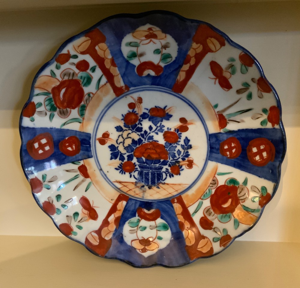 A set of four 19th-century Japanese Imari porcelain plates featuring scalloped rims and detailed cobalt blue and iron-red floral panelling. View VIII