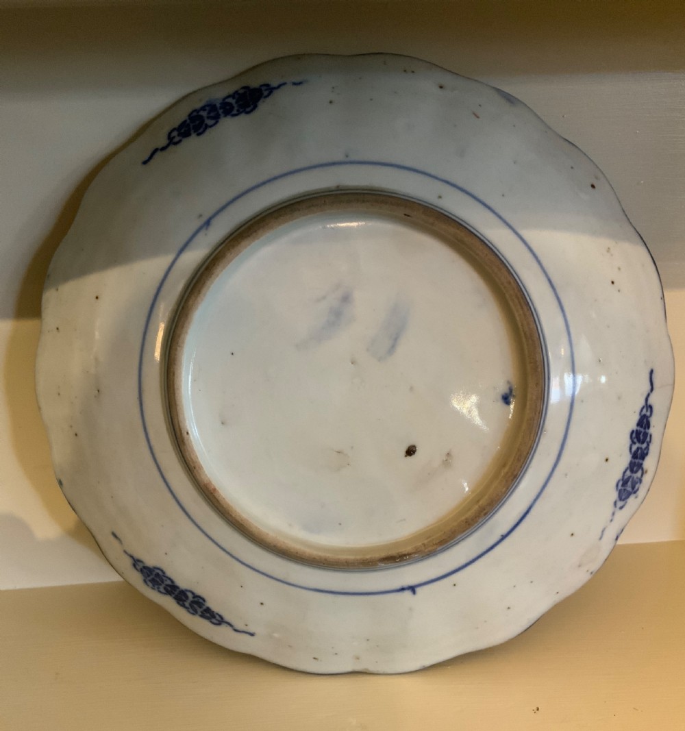 A set of four 19th-century Japanese Imari porcelain plates featuring scalloped rims and detailed cobalt blue and iron-red floral panelling. View IX