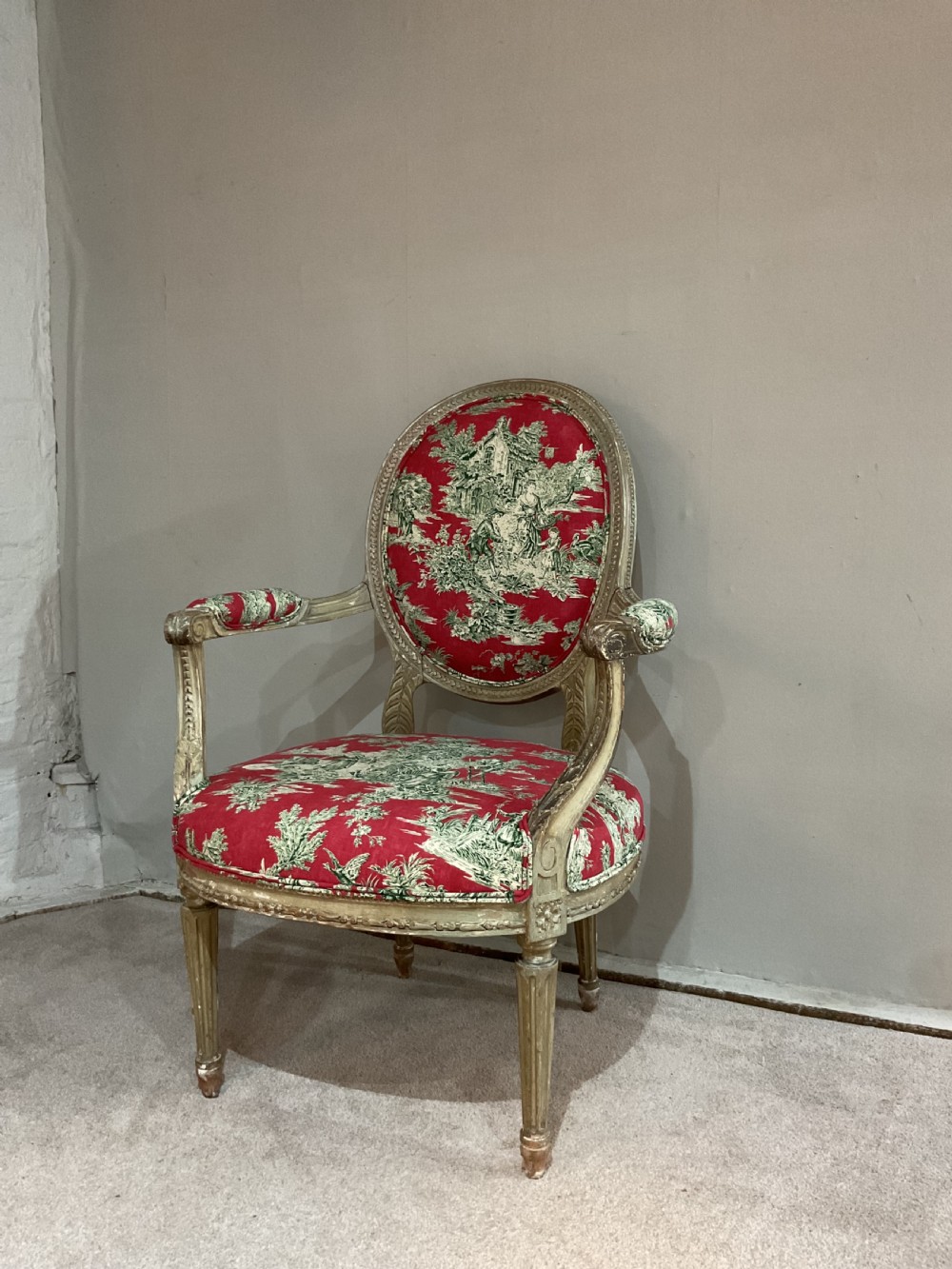 A pair of 18th-century French Louis XVI open armchairs featuring oval backrests, carved fluted legs, distressed gilding, and red patterned textile upholstery. View III