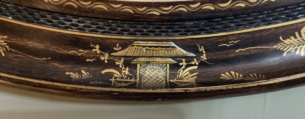 An oval Edwardian wall mirror featuring a dark lacquered frame decorated with hand-painted gold Chinoiserie scenes and figures. View III