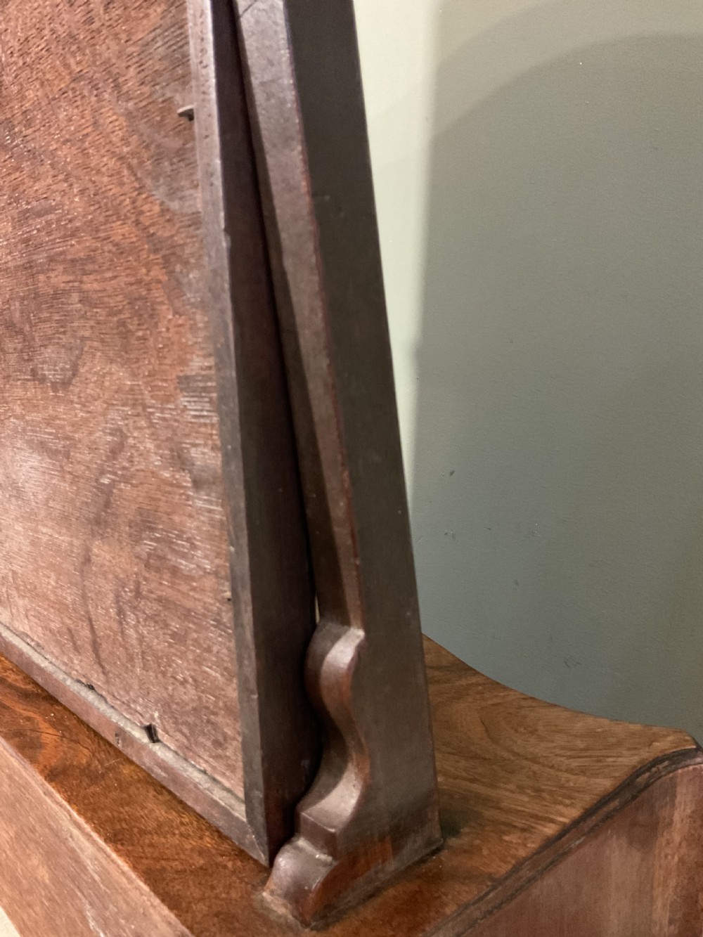 A George II period dark walnut toilet mirror featuring an arched adjustable swing frame set above a shaped three-drawer base with brass handles. View VIII