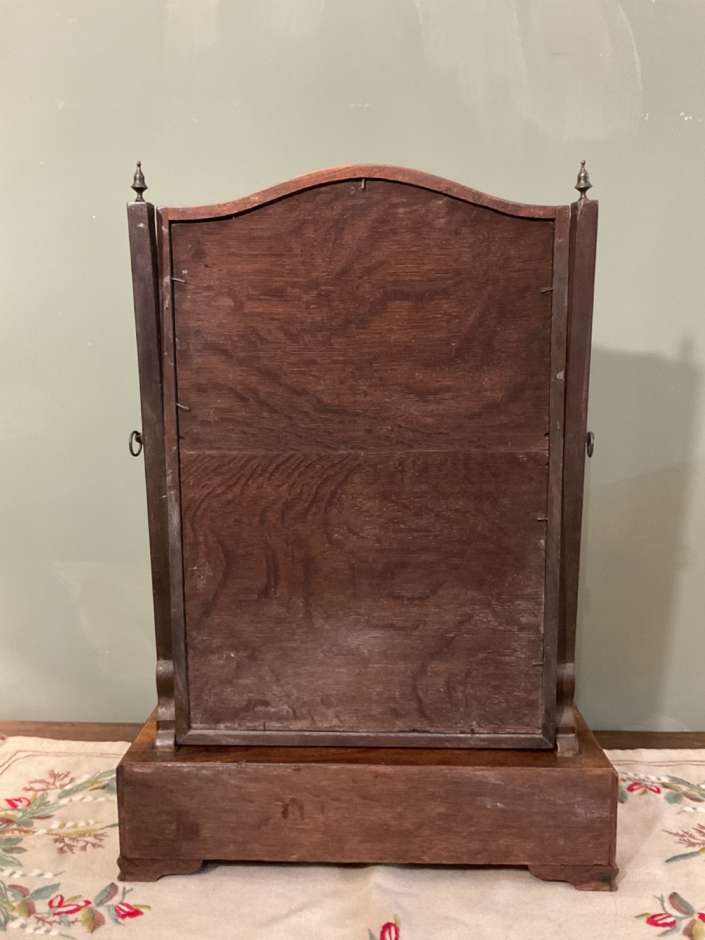 A George II period dark walnut toilet mirror featuring an arched adjustable swing frame set above a shaped three-drawer base with brass handles. View IX