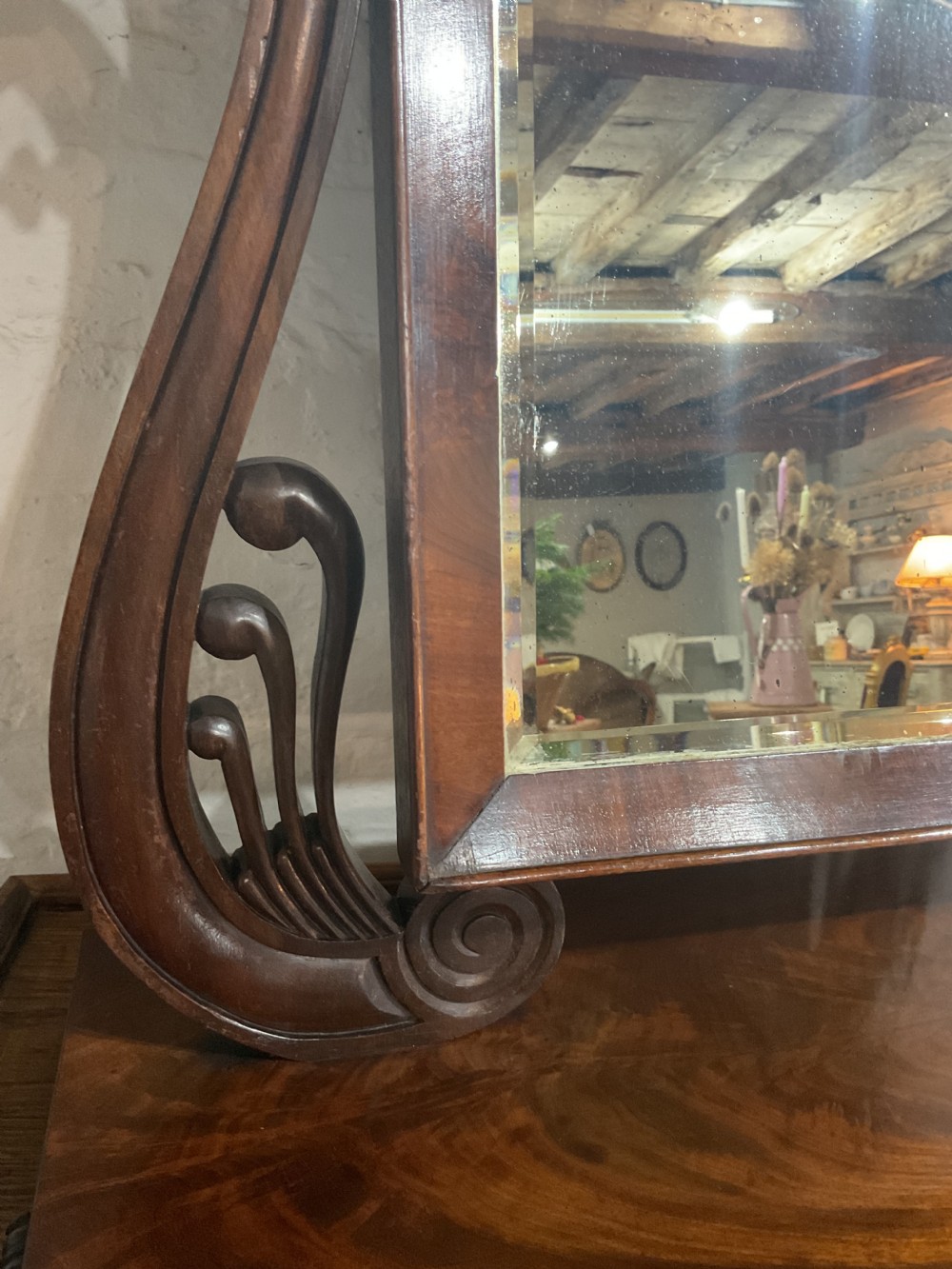 A Regency mahogany toilet mirror featuring a rectangular glass plate suspended between two carved scroll supports above a moulded plinth base. View IV