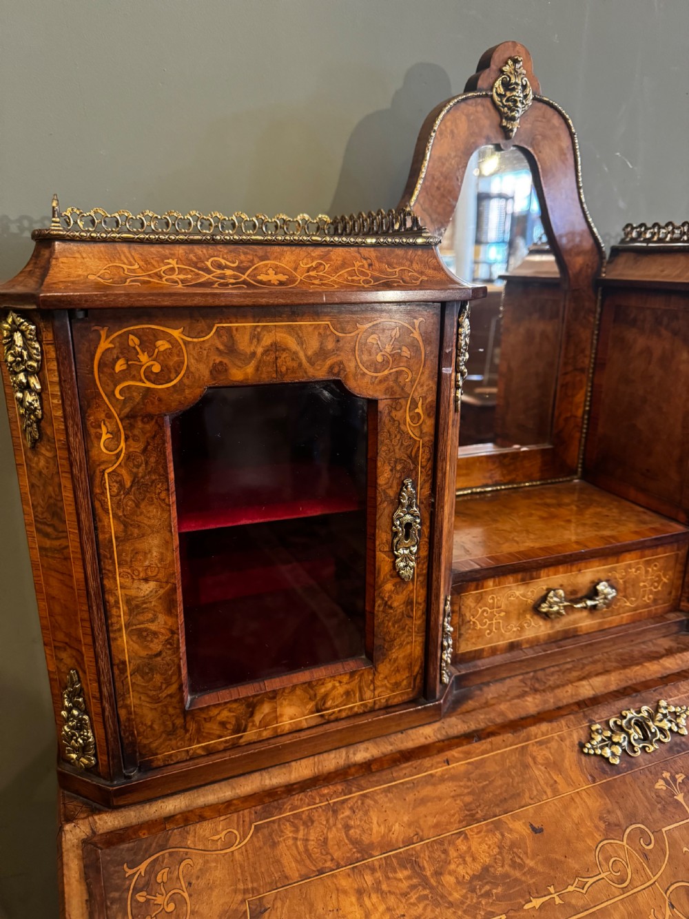 A burr walnut bonheur du jour writing desk featuring floral marquetry, cabriole legs with gilt bronze mounts, and an upper section with twin glazed cabinets framing a central mirror. View III