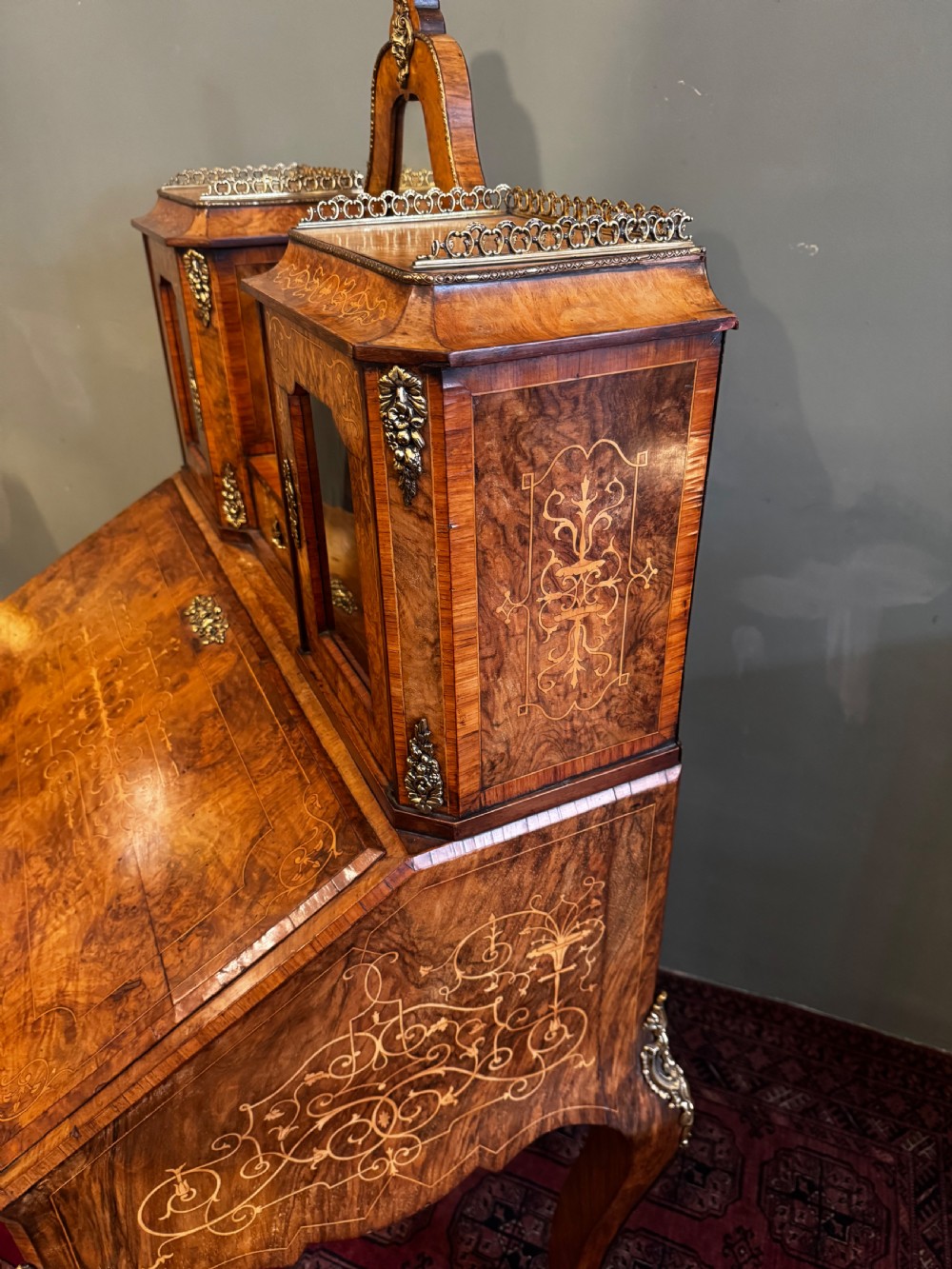 A burr walnut bonheur du jour writing desk featuring floral marquetry, cabriole legs with gilt bronze mounts, and an upper section with twin glazed cabinets framing a central mirror. View VIII