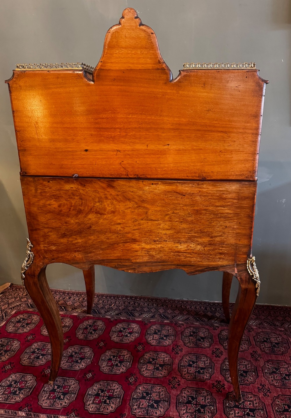 A burr walnut bonheur du jour writing desk featuring floral marquetry, cabriole legs with gilt bronze mounts, and an upper section with twin glazed cabinets framing a central mirror. View IX