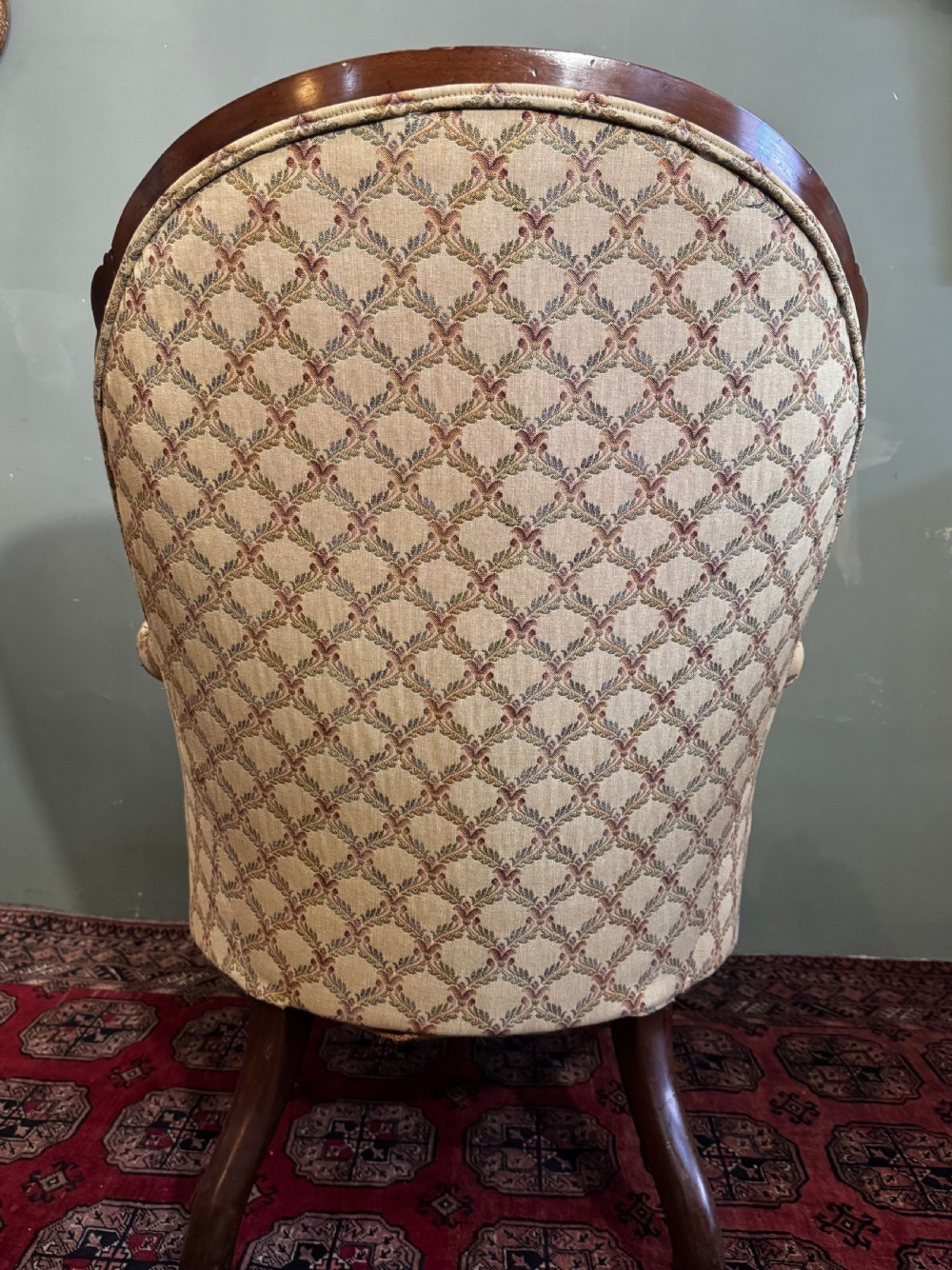 A Victorian mahogany armchair with patterned button-backed upholstery, carved wooden frame, and front cabriole legs. View VII