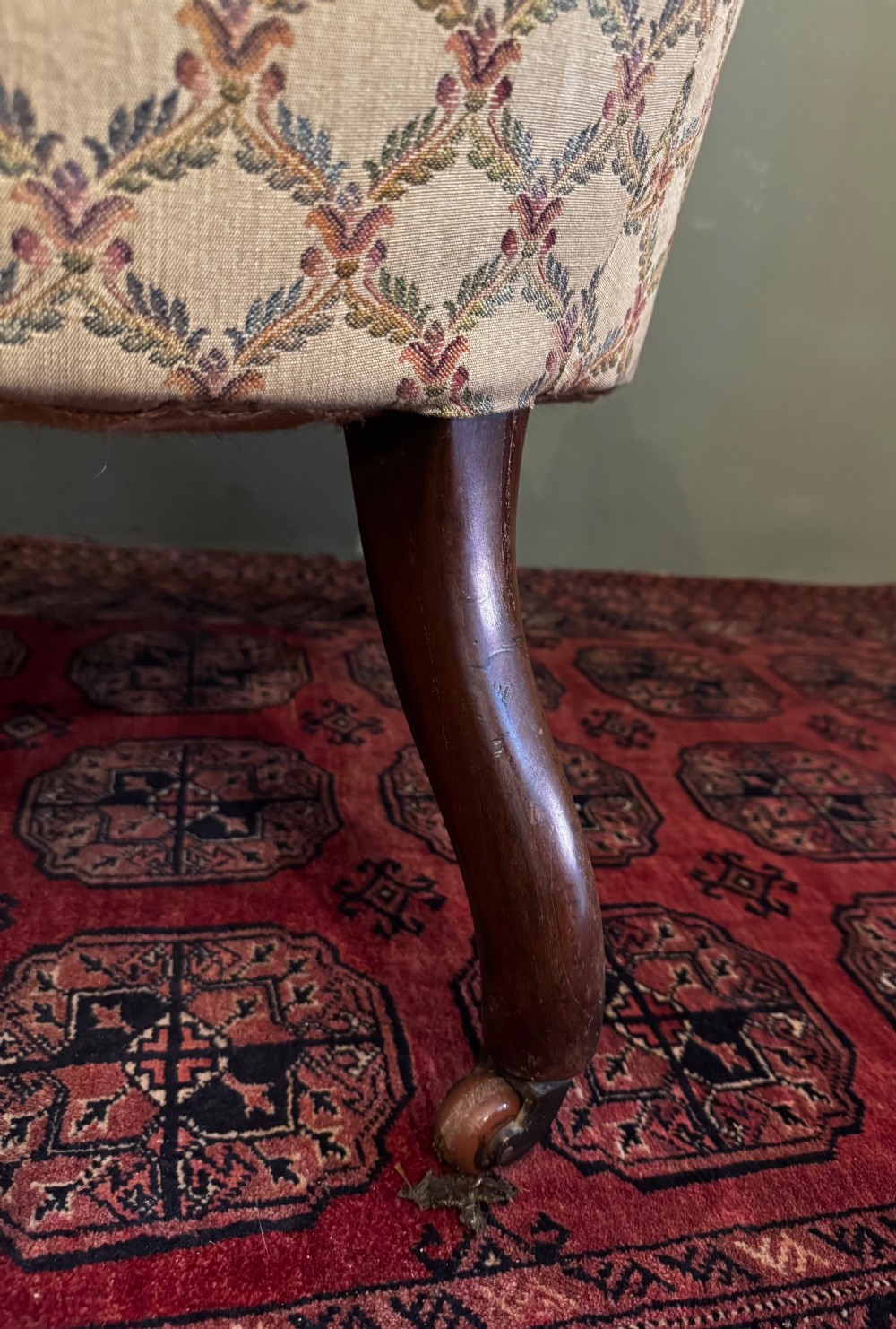 A Victorian mahogany armchair with patterned button-backed upholstery, carved wooden frame, and front cabriole legs. View VIII