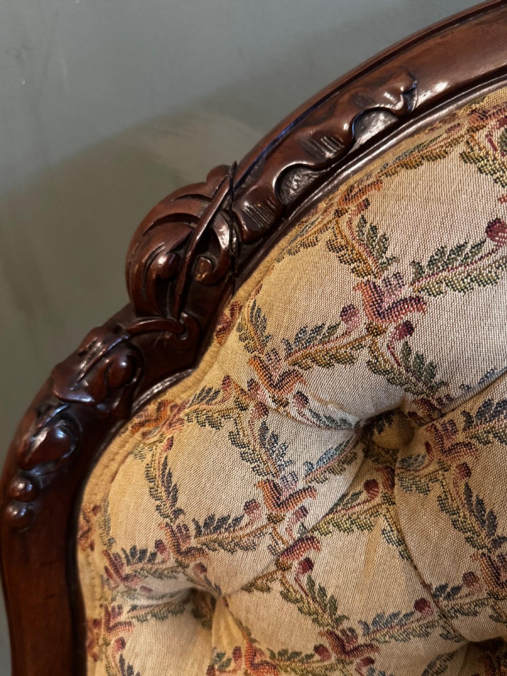 A Victorian mahogany armchair with patterned button-backed upholstery, carved wooden frame, and front cabriole legs. View IX