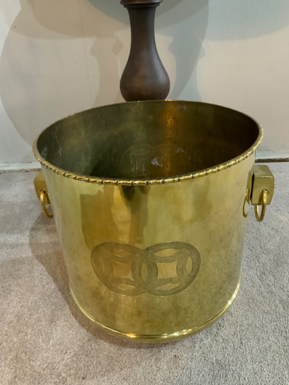 A pair of cylindrical polished brass planters featuring beaded rims, drop ring handles, and etched interlocking circle motifs. View IV