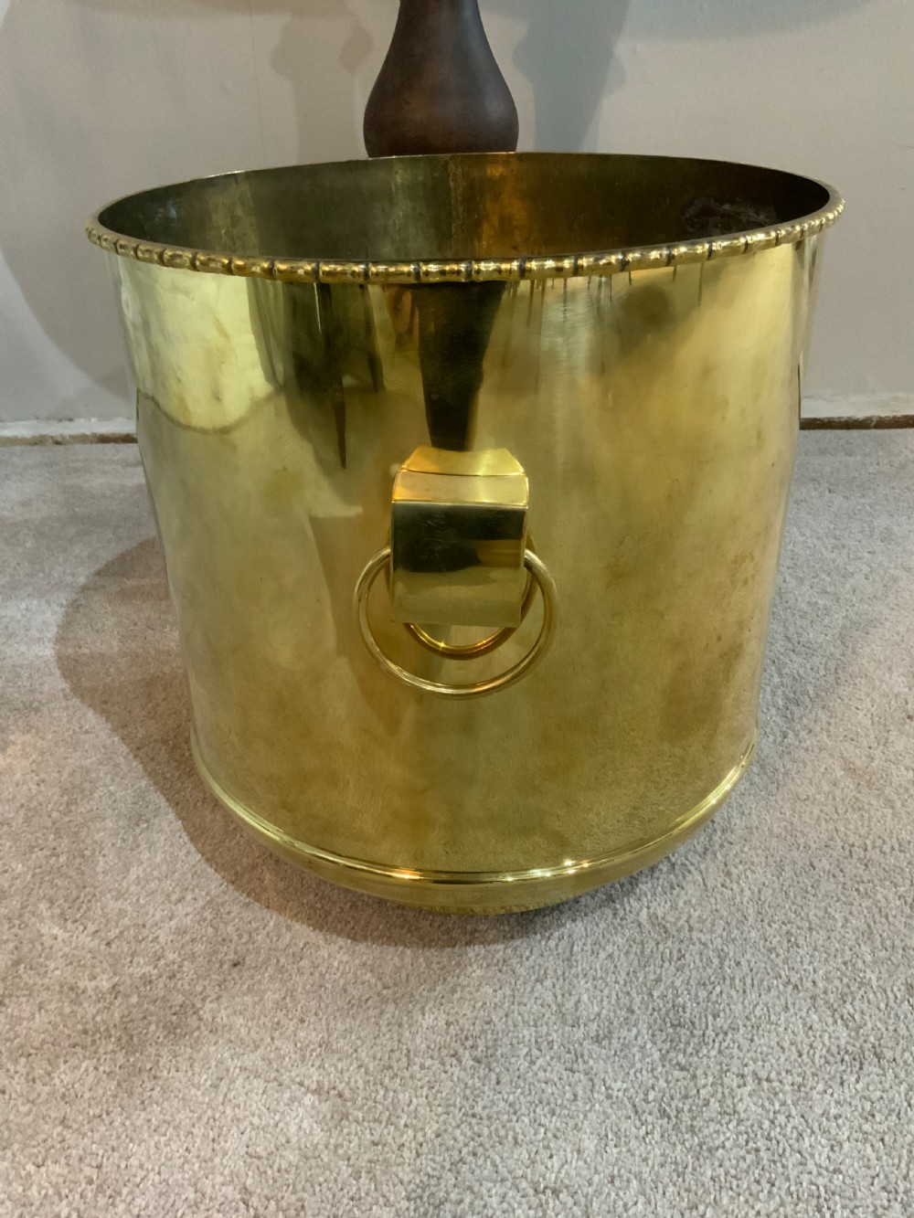 A pair of cylindrical polished brass planters featuring beaded rims, drop ring handles, and etched interlocking circle motifs. View V