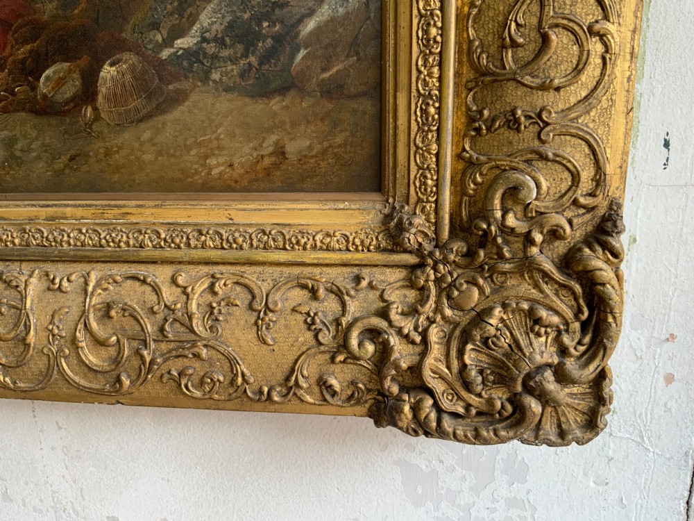 A 19th-century oil painting on canvas showing a coastal shoreline with sailing vessels, framed in an ornate gilded gesso frame. View IV
