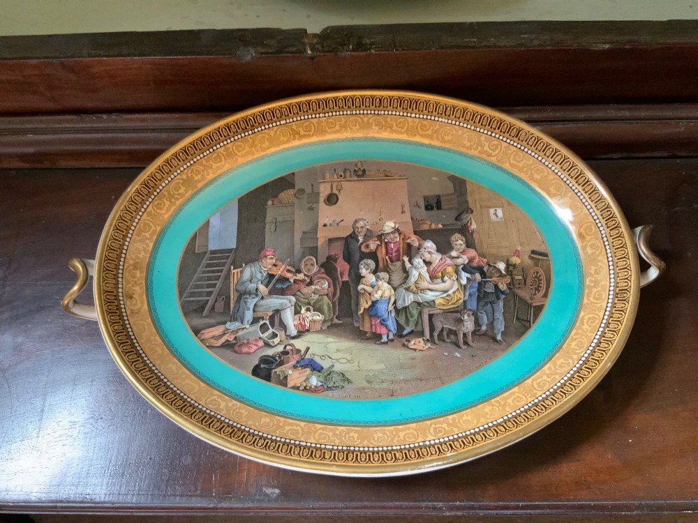 A twelve-piece collection of Victorian English Staffordshire Prattware ceramics including plates, mugs, and dishes with transfer-printed pictorial scenes and pink and gold borders. View II