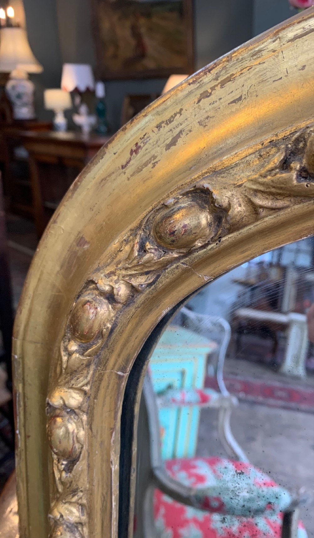 An early Victorian gold giltwood overmantel mirror featuring an arched top, beaded border moulding, and foliate scroll details at the base. View V