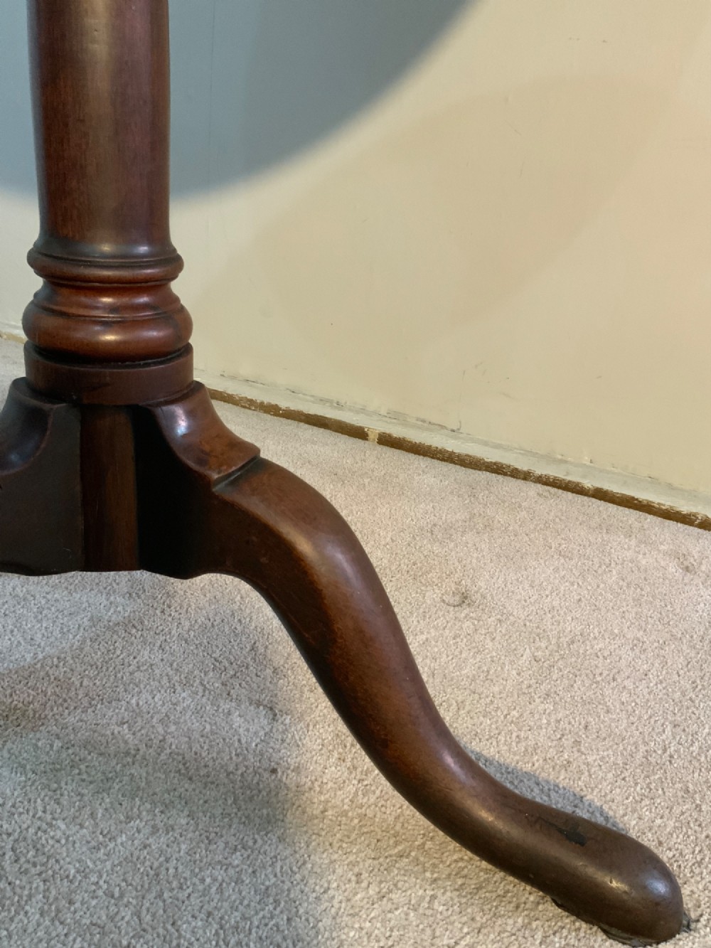A Georgian solid mahogany tripod table featuring a circular tray top with a raised rim, tilted vertically on a turned central pedestal with three cabriole legs. View V