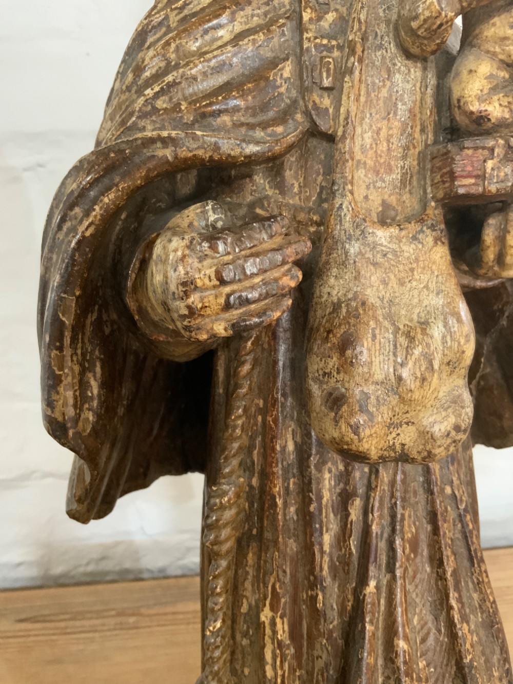 A carved wood figure representing Saint Anthony of Padua in a Franciscan habit holding the Christ Child on a open book. View VI
