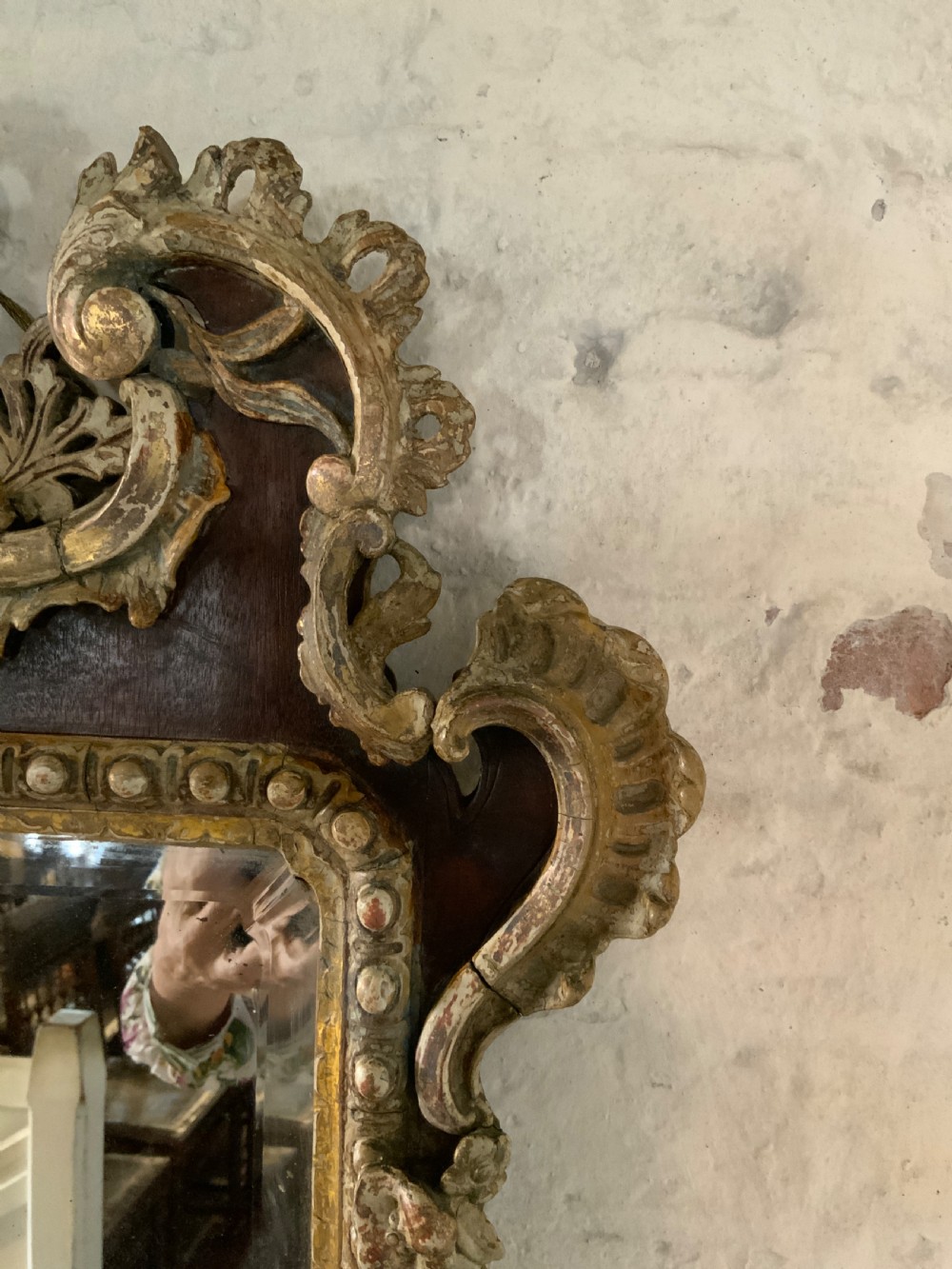 An 18th-century rectangular walnut wall mirror featuring elaborate parcel gilt carved cresting, bead moulding, and a decorative scrollwork apron. View IV