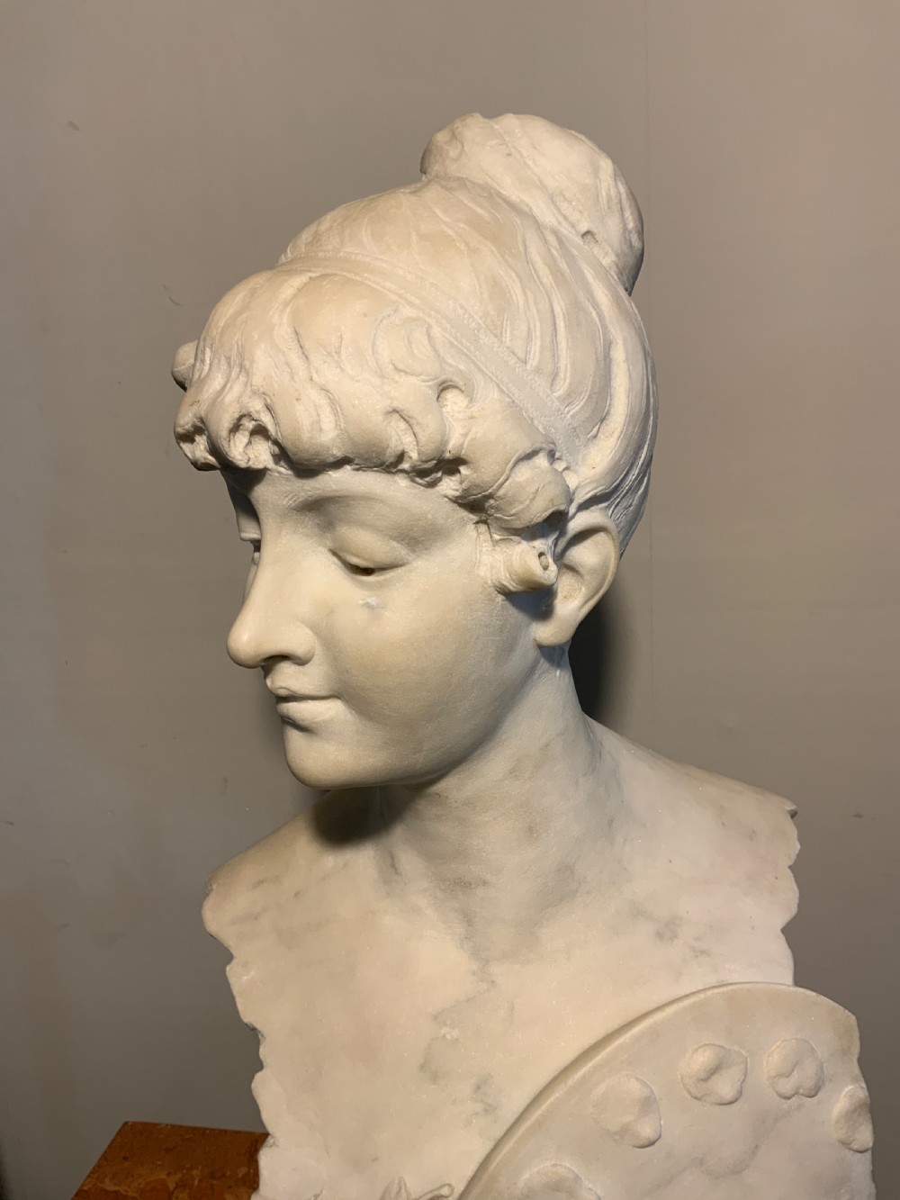A carved white Carrara marble bust of a female figure featuring an artist palette and carved floral details, mounted on a turned socle. View V